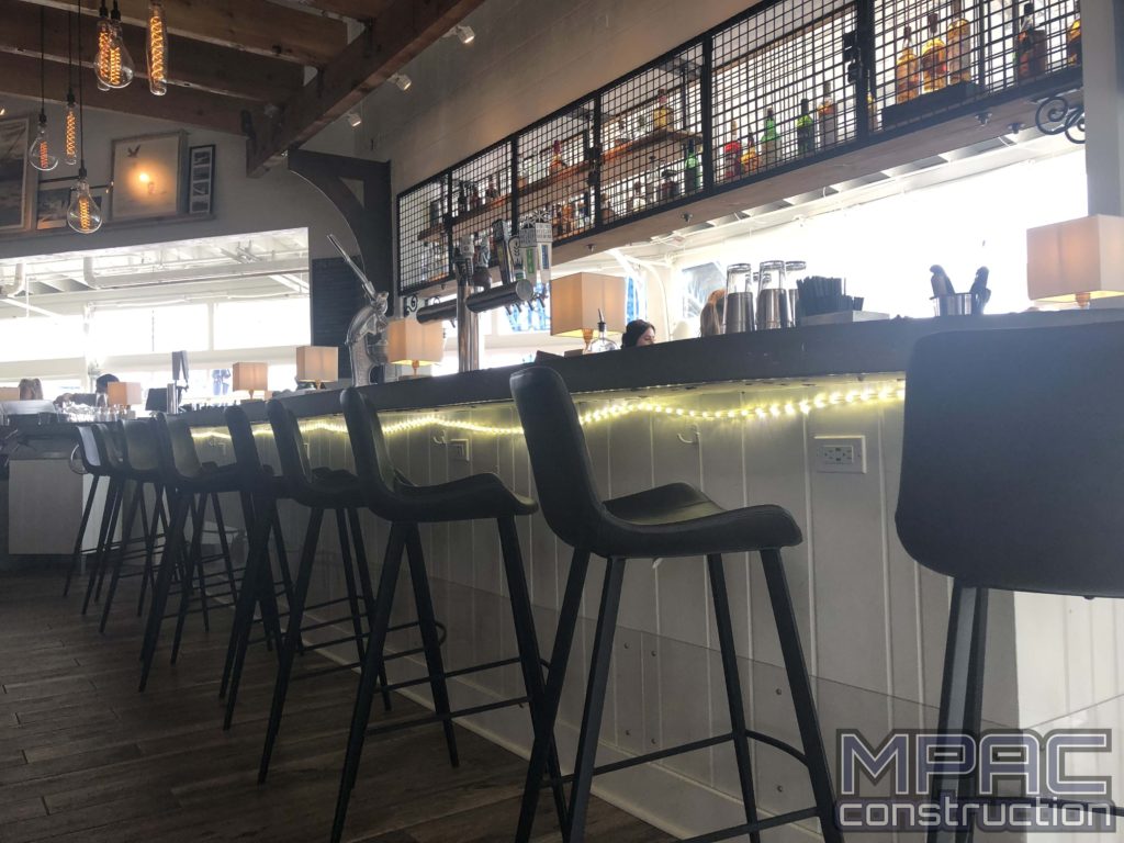 Commercial construction work in progress at a vibrant bar scene, with workers renovating and remodeling the space to create a modern and inviting atmosphere. We also offer home improvement!