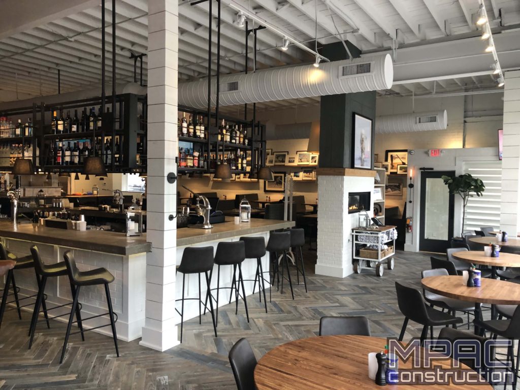 Commercial construction work in progress at a vibrant bar scene, with workers renovating and remodeling the space to create a modern and inviting atmosphere. We also offer home improvement!